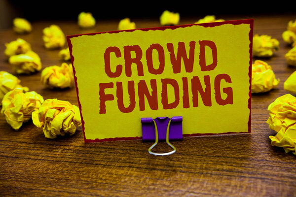 Word writing text Crowd Funding. Business concept for Fundraising Kickstarter Startup Pledge Platform Donations Clip holding yellow paper note crumpled papers several tries mistakes.