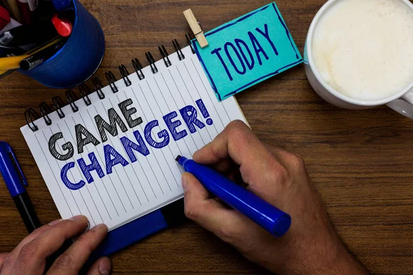 Text sign showing Game Changer. Conceptual photo Sports Data Scorekeeper Gamestreams Live Scores Team Admins Man holding marker notebook clothespin reminder wooden table cup coffee.