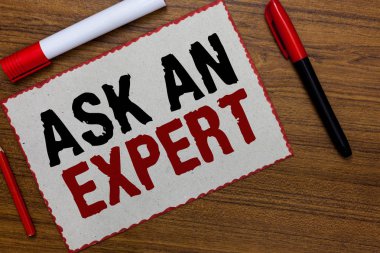 Text sign showing Ask An Expert. Conceptual photo Superior Reliable Ace Virtuoso Curiosity Authority Geek White paper red borders markers wooden background communicating ideas. clipart