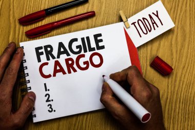 Kırılgan kargo yazma el yazısı metin. Kırılabilir ele umurumda Bubble Wrap cam tehlikeli ürünler marker defter clothespin hatırlatma ahşap masa fincan kahve holding adam ile anlam kavramı.