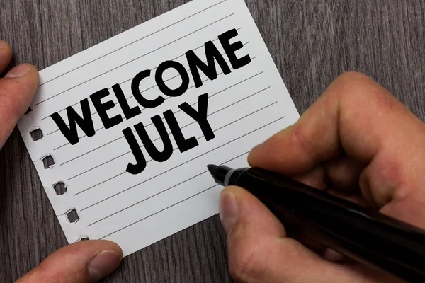 Conceptual hand writing showing Welcome July. Business photo showcasing Calendar Seventh Month 31days Third Quarter New Season Man holding marker notebook page Wooden background. — Stock Photo, Image