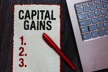 Sermaye kazançları yazma el yazısı metin. Siyah kalemi bilgisayar klavye ahşap arka plan tahvil hisse hisse senetleri kar gelir vergisi yatırım fonları parça kağıt kırmızı kenarlıklar anlam kavramı.