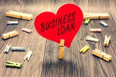 Word metin yazma işletme kredisi. İş kavramı için kredi Mortgage mali yardım nakit avans borç birkaç clothespins ahşap zemin romantik kırmızı kağıt kalp tutan Clothespin.