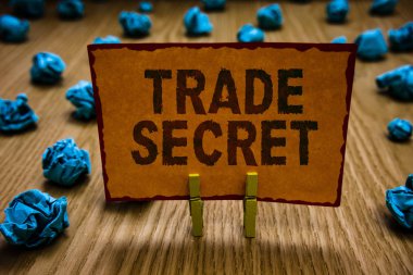 Kavramsal el ticari sır gösterilen yazma. İş fotoğraf metin bir ürün fikri mülkiyet ile ilgili gizli bilgileri turuncu kağıt buruşuk not kağıtları tutan Clothespins hata.