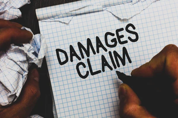 Handwriting text Damages Claim. Concept meaning Demand Compensation Litigate Insurance File Suit Man holding marker notebook crumpled papers ripped pages mistakes made.