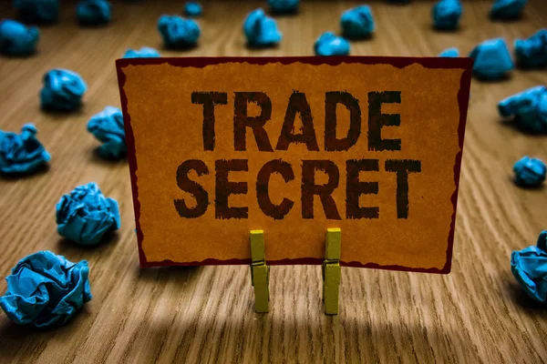 Kavramsal el ticari sır gösterilen yazma. İş fotoğraf metin bir ürün fikri mülkiyet ile ilgili gizli bilgileri turuncu kağıt buruşuk not kağıtları tutan Clothespins hata.
