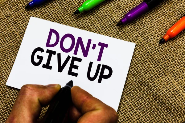 Scrivere una nota che mostra Don't Give Up. Business photo showcase Determined Perseverare Continua a credere in te stesso Uomo mano che tiene il pennarello carta bianca idea di comunicazione iuta sfondo . — Foto Stock