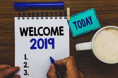 Kavramsal el hoş geldiniz 2019 gösterilen yazma. İş fotoğraf metin yeni yıl kutlama motivasyon alkış Tebrikler marker defter clothepin hatırlatma ahşap masa kahve tutan adam başlatmak için.