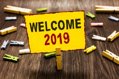 Hoşgeldiniz 2019 yazma el yazısı metin. Yeni yıl kutlama motivasyon alkış Tebrikler birkaç clothespins ahşap zemin sarı kağıt Not tutarak Clothespin başlatmak için anlam kavramı.