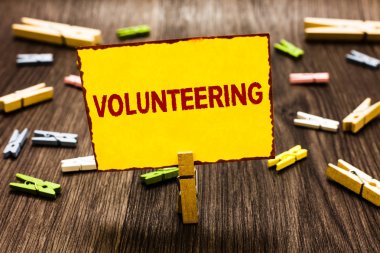 Gönüllülük yazma el yazısı metin. Hiçbir maddi kazanç sağlamak isteyerek zorlamak birkaç clothespins ahşap zemin sarı kağıt Not tutarak Clothespin sağlamak hizmetleri anlam kavramı.