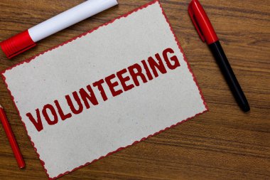 Gönüllülük gösterilen metin işareti. Kavramsal fotoğraf sağlamak hizmetleri için hiçbir maddi kazanç isteyerek zorlamak beyaz kağıt kırmızı kenarlıklar fikirler iletişim işaretleri ahşap arka plan.