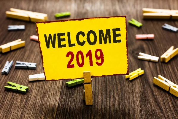 Hoşgeldiniz 2019 yazma el yazısı metin. Yeni yıl kutlama motivasyon alkış Tebrikler birkaç clothespins ahşap zemin sarı kağıt Not tutarak Clothespin başlatmak için anlam kavramı.