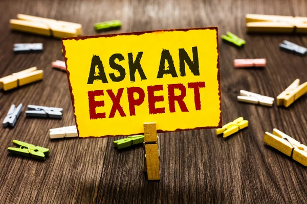 Bir uzman sormak yazma el yazısı metin. Çift güvenilir Ace virtüözü merak yetkilisi Geek birkaç clothespins ahşap zemin sarı kağıt Not tutarak Clothespin anlam kavramı.