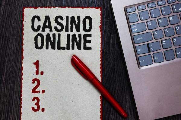 Handwriting text writing Casino Online. Concept meaning Computer Poker Game Gamble Royal Bet Lotto High Stakes Piece paper red borders black marker computer keyboard wooden background.