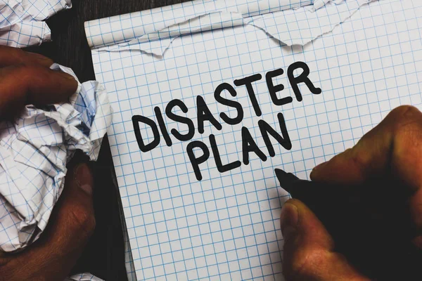 Handwriting text Disaster Plan. Concept meaning Respond to Emergency Preparedness Survival and First Aid Kit Man holding marker notebook crumpled papers ripped pages mistakes made.