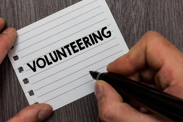 Kavramsal el gönüllülük gösterilen yazma. İş fotoğraf vitrine sağlamak hizmetleri hiçbir maddi kazanç için isteyerek işaret defter sayfası ahşap arka plan tutan adam mecbur.