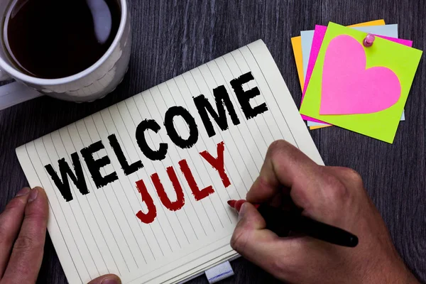 Conceptual hand writing showing Welcome July. Business photo text Calendar Seventh Month 31days Third Quarter New Season Man holding marker giving ideas wooden table cup coffee hearts. — Stock Photo, Image