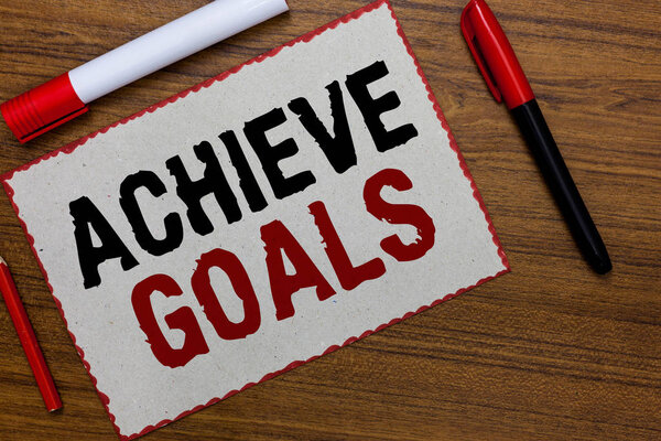 Text sign showing Achieve Goals. Conceptual photo Results oriented Reach Target Effective Planning Succeed White paper red borders markers wooden background communicating ideas.