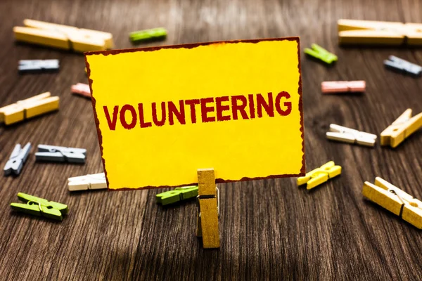 Gönüllülük yazma el yazısı metin. Hiçbir maddi kazanç sağlamak isteyerek zorlamak birkaç clothespins ahşap zemin sarı kağıt Not tutarak Clothespin sağlamak hizmetleri anlam kavramı.