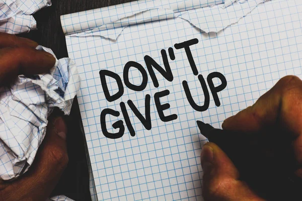 Handwriting text Don t not Give Up. Concept meaning Determined Persevering Continue to Believe in Yourself Man holding marker notebook crumpled papers ripped pages mistakes made.
