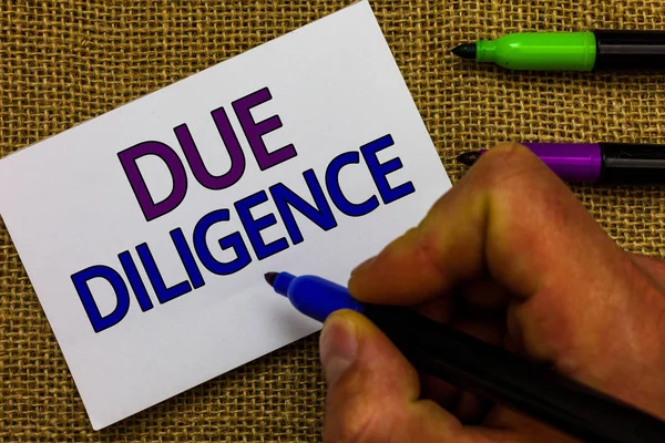 Due Diligence gösterilen metin işareti. Kavramsal fotoğraf kapsamlı değerlendirme gönüllü soruşturma denetim adam el işaretçisi beyaz kağıt fikirler Jüt arka plan iletişim tutarak.