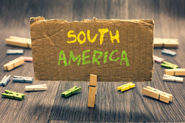 Writing note showing South America. Business photo showcasing Continent in Western Hemisphere Latinos known for Carnivals Clothespin holding paperboard important communicating message ideas. — Stock Photo, Image