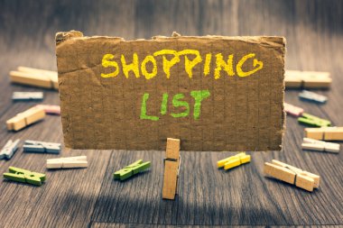 Alışveriş listesinde gösterilen Not yazma. Disiplin yaklaşımı temel öğeleri önemli iletişim mesaj fikir karton tutan Clothespin satın almak için alışveriş için vitrine iş fotoğraf