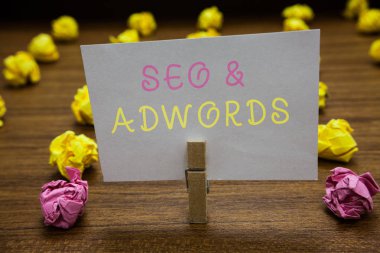 SEO ve Adwords yazma el yazısı metin. Google Adsense beyaz kağıt Not tutarak Clothespin pazarlama dijital buruşuk ödeme tıklama başına anlam kavramı birkaç çalışır hata kağıtları.