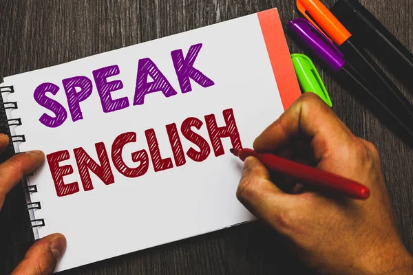 Escritura manual conceptual que muestra hablar inglés. Texto de foto de negocios Estudie otra lengua extranjera Cursos verbales en línea Hombre sosteniendo papel de cuaderno comunicando ideas Fondo de madera . — Foto de Stock