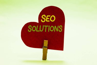 SEO çözümleri gösterilen Not yazma. Arama motoru sonuç sayfası artırmak ziyaretçi tarafından sıralaması kırmızı kağıt kalp önemli romantik mesaj fikirler tutan Clothespin vitrine iş fotoğraf.