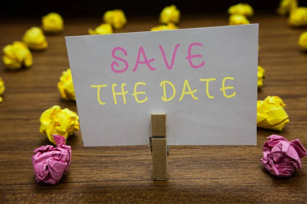 Handwriting text writing Save The Date. Concept meaning Systematized events Scheduled activity Recorded Filed Clothespin holding white paper note crumpled papers several tries mistakes. — Stock Photo, Image