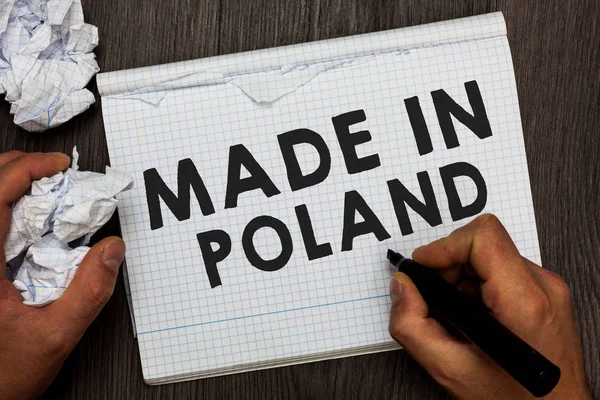 Uwaga: pisanie Wyświetlono Made In Poland. Zdjęcie biznesowych prezentacji produktu lub coś, która jest produkowana w Polsce człowiek trzyma znacznik notebook pogniecione dokumentami kilku próbach wykonane. — Zdjęcie stockowe