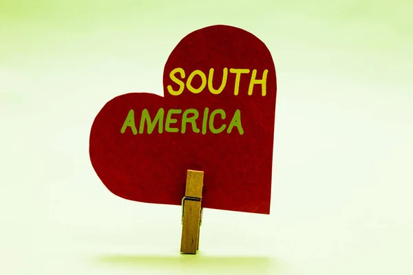 Writing note showing South America. Business photo showcasing Continent in Western Hemisphere Latinos known for Carnivals Clothespin holding red paper heart important romantic message ideas. — Stock Photo, Image