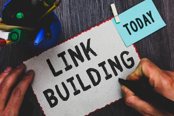 Conceptual hand writing showing Link Building. Business photo text SEO Term Exchange Links Acquire Hyperlinks Indexed Man holding marker paper clothespin reminder cup marker wood table. — Stock Photo, Image