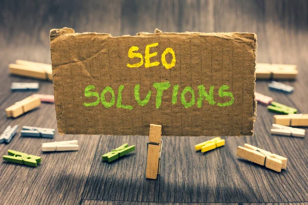 Writing note showing Seo Solutions. Business photo showcasing Search Engine Result Page Increase Visitors by Rankings Clothespin holding paperboard important communicating message ideas. — Stock Photo, Image