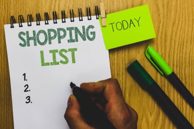 Word metin yazma alışveriş listesi. İş kavramı disiplin yaklaşımı temel öğeleri işaret defter clothespin hatırlatma ahşap masa fincan kahve tutan adam satın almak için alışveriş için.