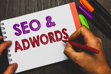 Kavramsal el yazma SEO gösterilen ve Adwords. İş fotoğraf metin ödeme tıklama başına Google Adsense defter kağıt fikirler iletişim holding adam pazarlama dijital ahşap arka plan.