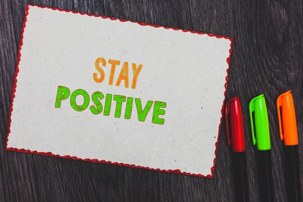 Text sign showing Stay Positive. Conceptual photo Engage in Uplifting Thoughts Be Optimistic and Real White paper red borders colorful markers wooden background expressing ideas.