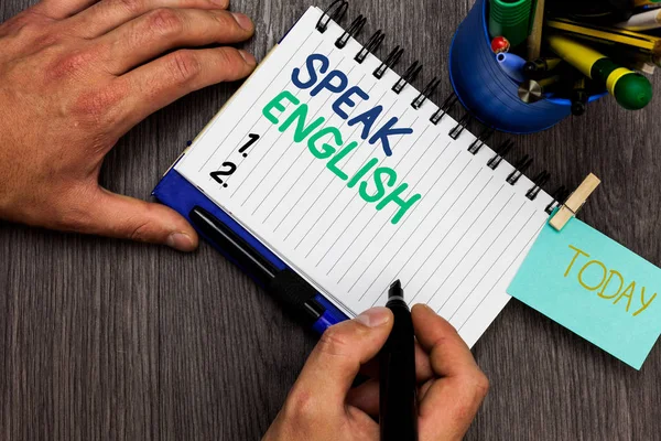 Escritura manual conceptual que muestra hablar inglés. Muestra de fotos de negocios Estudie otra lengua extranjera Cursos verbales en línea Hombre sosteniendo marcador portátil recordatorio taza marcadores mesa de madera . —  Fotos de Stock