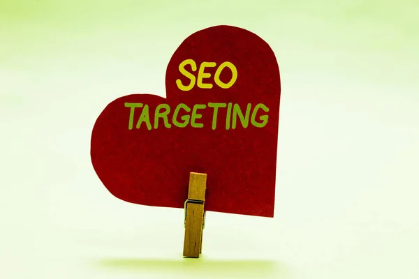 Nota de escritura que muestra Seo Targeting. Palabras clave específicas para la ubicación Landing Page Top Domain Clothespin holding red paper heart ideas importantes mensaje romántico . —  Fotos de Stock