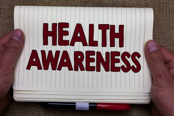 Handwriting text writing Health Awareness. Concept meaning Promoting community issues and preventative action Man hands holding notebook open page jute background Expressing ideas. — Stock Photo, Image