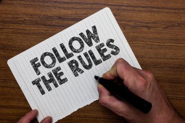 The Rules izleyin gösterilen Not yazma. İş fotoğraf sipariş biri sopa bazı yere vitrine ülke Rehberleri stricts işaretçisi defter kağıt ifade fikirler ahşap arka plan tutan adam.