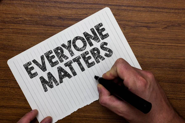 Writing note showing  Everyone Matters. Business photo showcasing all the people have right to get dignity and respect Man holding marker notebook paper expressing ideas wooden background.