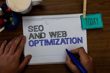 Kavramsal el SEO ve Web optimizasyonu gösterilen yazma. İş fotoğraf vitrine arama motoru Keywording pazarlama stratejileri el tutun kalemi ataş yazılı not defteri kalem durumda kahve kupa.