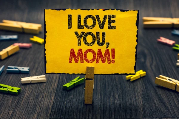 Σύνταξη κειμένου λέξη ' αγαπώ μαμά. Επιχειρηματική ιδέα για αγαπώντας μήνυμα χάρτου Blacky ξύλινο γραφείο με αγάπη θερμή δήλωση clip τυχαία μία συναισθηματική αισθήματα κρατήστε κίτρινο πίνακας με το κείμενο. — Φωτογραφία Αρχείου