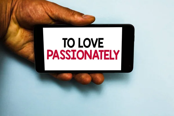 Handwriting text To Love Passionately. Concept meaning Strong feeling for someone or something else Affection Human hand hold mobile phone with some black and red color letters.