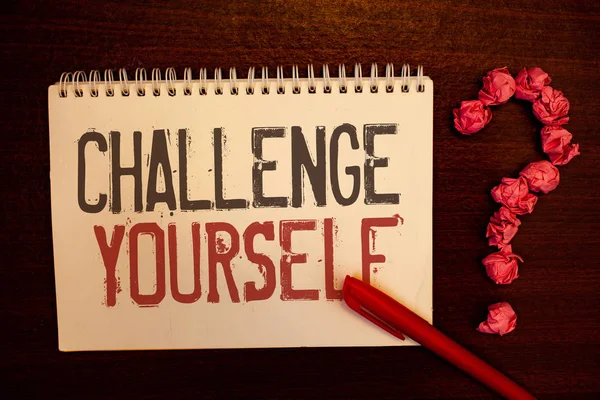 Handwriting text Challenge Yourself. Concept meaning Overcome Confidence Strong Encouragement Improvement Dare Reddish paper balls structures question mark red pen notebook browny desk.