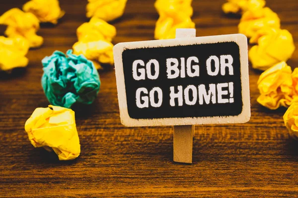 Text sign showing Go Big Or Go Home Motivational Call. Conceptual photo Mindset Ambitious Impulse Persistence Blackboard with letters wooden floor blurry yellow paper lumps green lob.