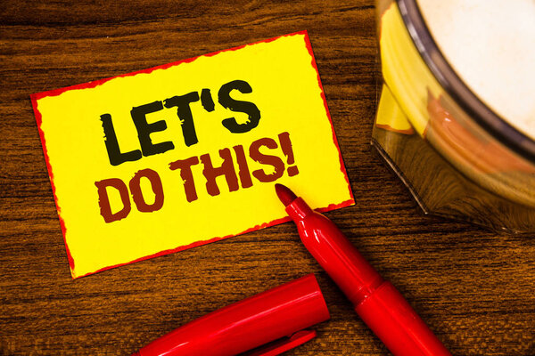 Writing note showing  Let Us Do This Motivational Call. Business photo showcasing Encourage to start something Inspirational Words yellow paper note red border open marker cap coffee glass desk.