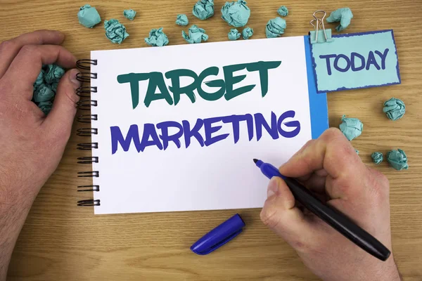 Writing note showing Target Marketing. Business photo showcasing Market Segmentation Audience Targeting Customer Selection Text two words blue white notepad blue marker hand crumbled blue paper.